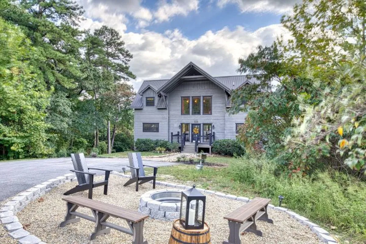 A welcoming fire pit encircled by comfortable seating, nestled in a landscaped garden with views of the modern cabin and sunset sky. The setup invites groups to gather, share stories, and enjoy tranquil evenings surrounded by nature.